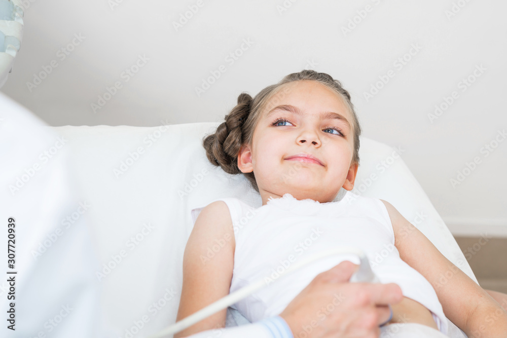 Sonographer moving transducer on belly of girl Sonographer moving transducer on belly of girl
