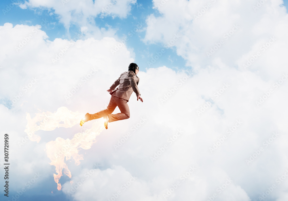 Businessman in suit and aviator hat flying in sky Businessman in suit and aviator hat flying in sky