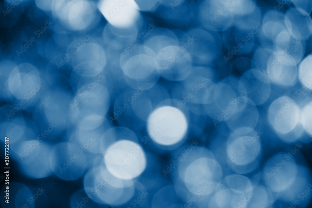 Classic blue lights bokeh background, Chrismas lights bokeh. Classic blue abstract background. Blurred and glowing lights. Classic blue bokeh lens effect from lighting spots. Classic blue lights bokeh background, Chrismas lights bokeh. Classic blue abstract background. Blurred and glowing lights. Classic blue bokeh lens effect from lighting spots.