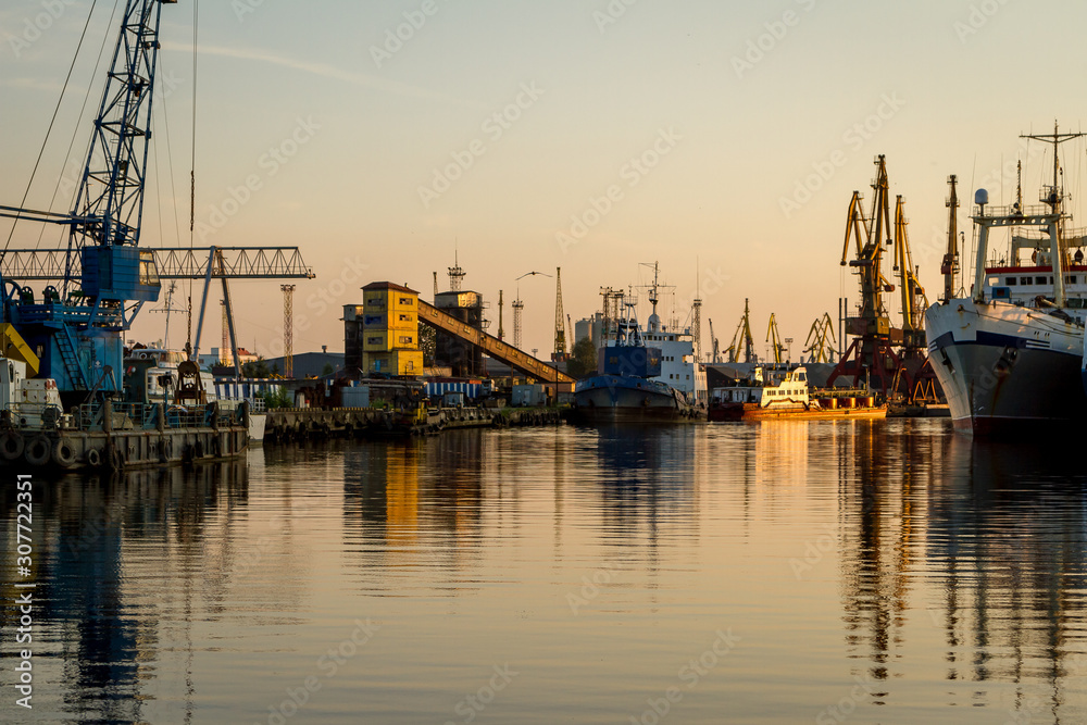 Russia, Kaliningrad, hoisting cranes in the commercial port at sunset Russia, Kaliningrad, hoisting cranes in the commercial port at sunset