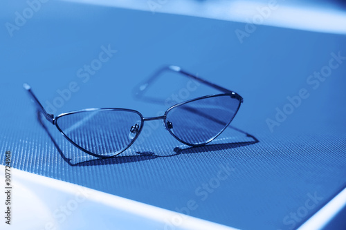 Fashion sunglasses on sunbed in blue color.