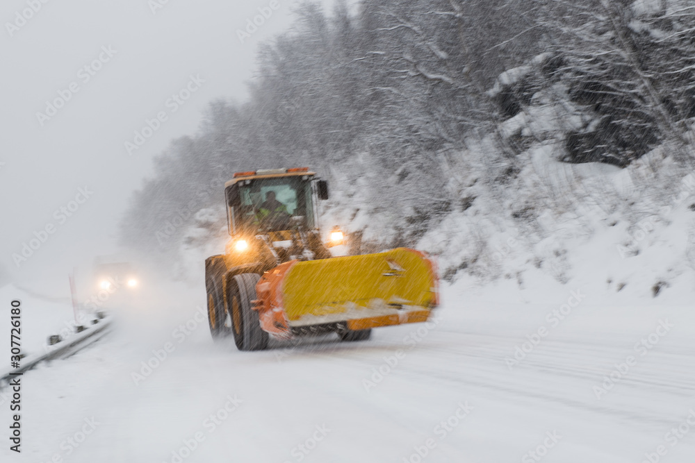 Blurred snow grader during heavy snowfall on the road Blurred snow grader during heavy snowfall on the road