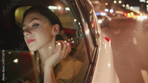 Young beautiful passenger in the backseat of the car is reading e-mails on her tablet photo