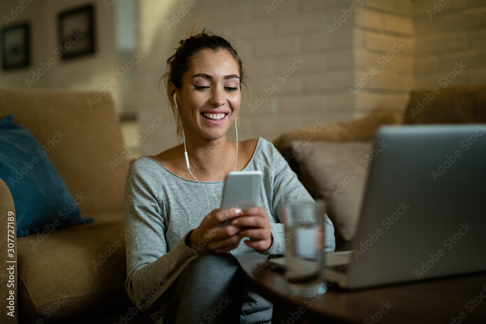 Happy woman text messaging on cell phone while relaxing in the living room. Happy woman text messaging on cell phone while relaxing in the living room.