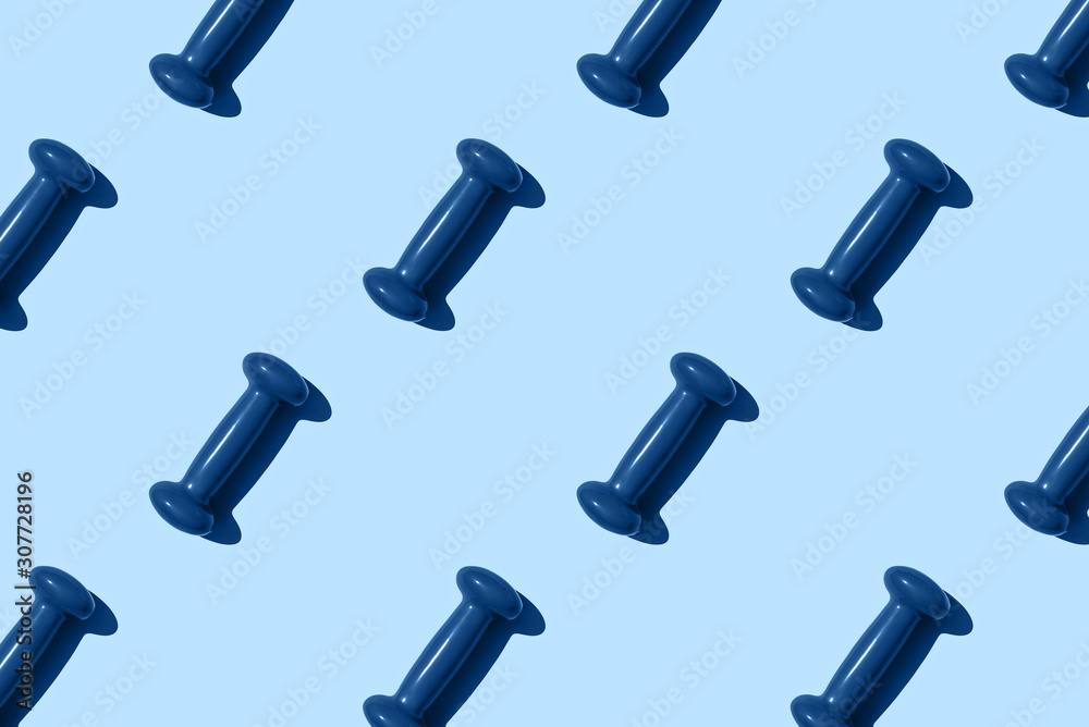 Blue dumbbell pattern on blue background. Creative sports layout. Blue dumbbell pattern on blue background. Creative sports layout.