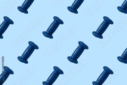 Blue dumbbell pattern on blue background. Creative sports layout.