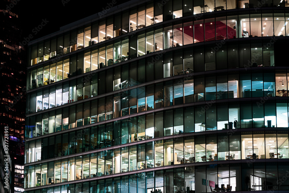 Modern offices in a large glass fronted building at night