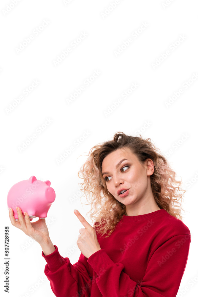 attractive girl talking with a piggy bank in hands on a white studio background attractive girl talking with a piggy bank in hands on a white studio background