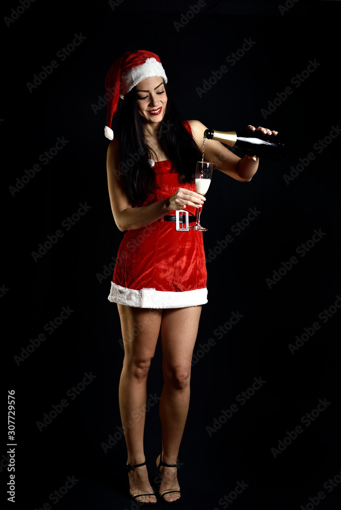 beautiful young woman with bottle and glass of champagne, on black background. Traditional parties concept. beautiful young woman with bottle and glass of champagne, on black background. Traditional parties concept.