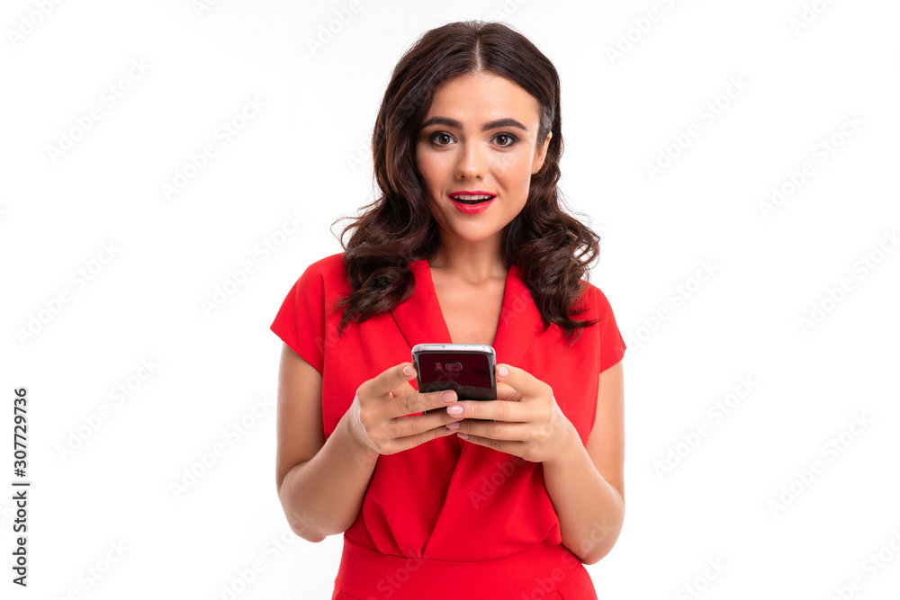 luxurious brunette girl in a red dress with a phone in her hands on a white background luxurious brunette girl in a red dress with a phone in her hands on a white background