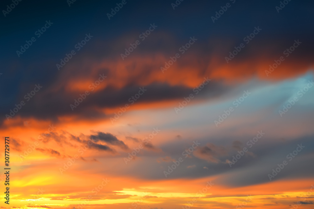 Dark thunderclouds on a golden sky during sunset. Afterglow of sunset. Scenic sundown cloudscape for background.