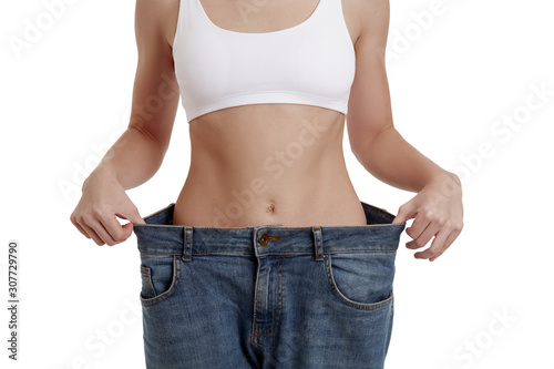 Perfect, slim, young body of a girl in white underwear. Weight loss and healthy eating. A woman in jeans of large size. The problem of obesity. Plastic surgery.