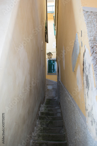 A narrow street with stairs leading up.