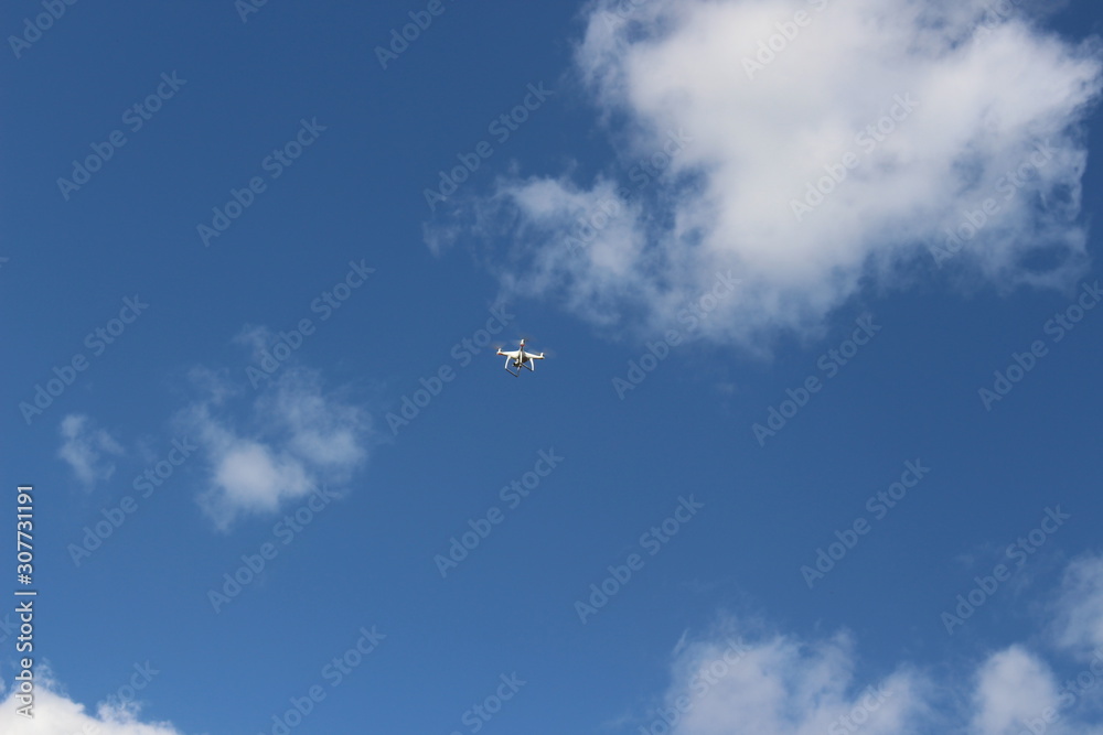 Drone against the blue sky on a sunny day. quadcopter flying through the sky. Aerial photo and video technology Drone against the blue sky on a sunny day. quadcopter flying through the sky. Aerial photo and video technology