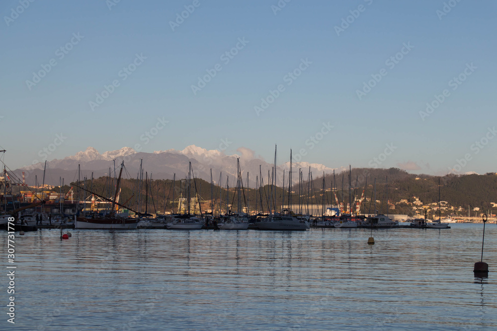 Boats in the seaport at sunset with mountains on background, La Spezia, Liguria, Italy.
