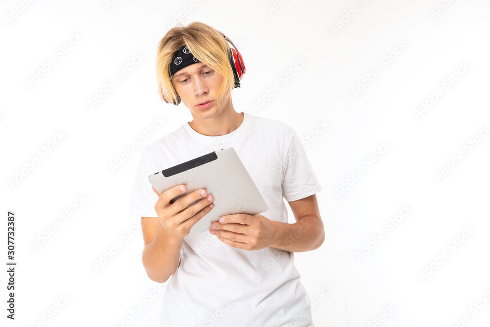 Stylish caucasian blonde man shows tablet isolated on white background Stylish caucasian blonde man shows tablet isolated on white background