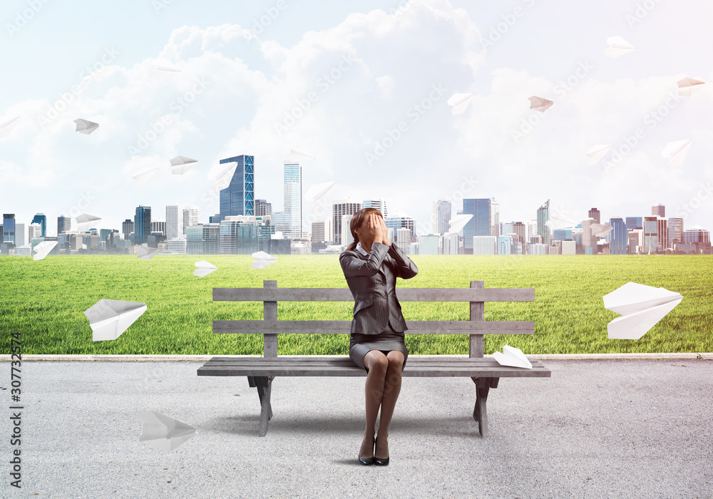 Young woman sitting on wooden bench outdoors Young woman sitting on wooden bench outdoors