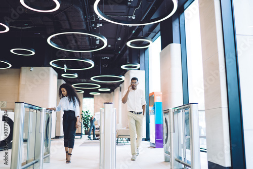 Successful coworkers walking through automatic access control at workplace