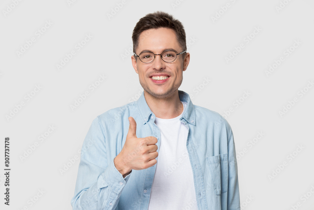 Head shot of smiling handsome man holding thumb up Head shot of smiling handsome man holding thumb up