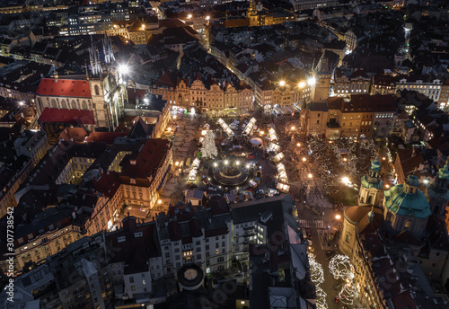 Prague, Czech Republic - Aerial view of the famous traditional Christmas market at Old Town Square at dusk with illuminated Church of our Lady Before Tyn and Old Town Hall at background