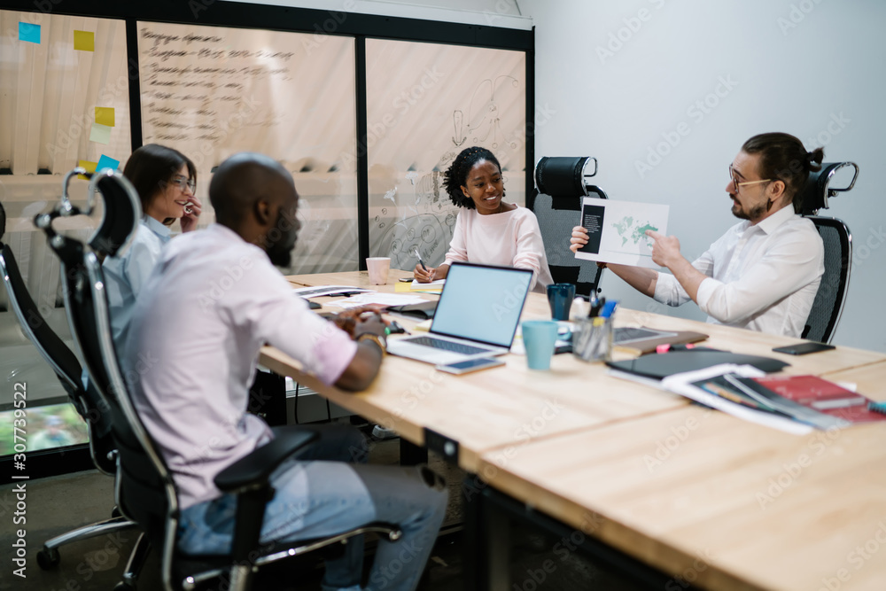 Colleague showing diagram to employees in office