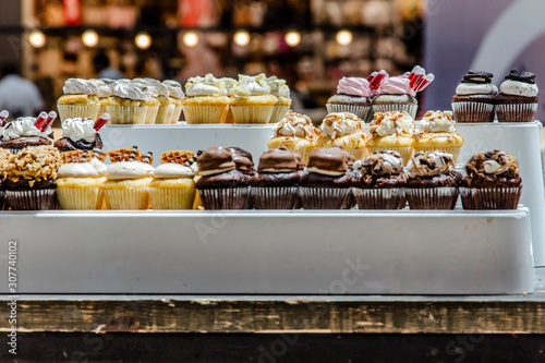 Cakes in the bakery window. Rich variety of chocolates and candies in display window of pastry shop. Cookies showcase