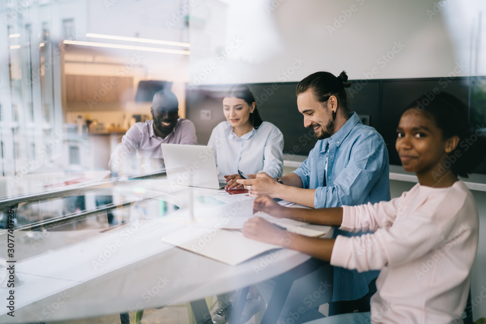Fototapeta premium Smiling coworkers sitting table in office space
