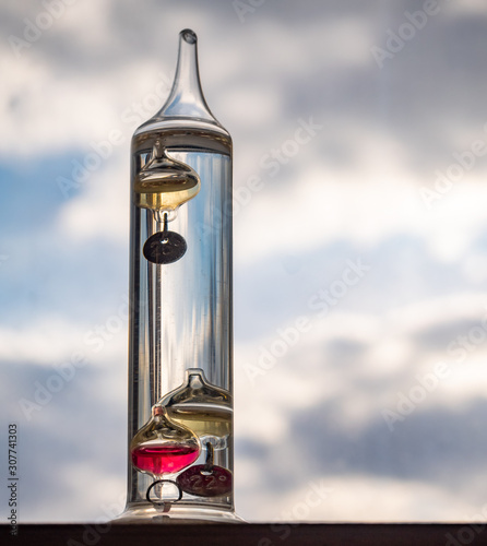 Galileo thermometer on empty sky background photo