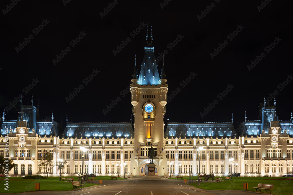 Fototapeta premium Clock tower of the Palace of Culture in Iasi, Romania. Evening illumination of the palace, cityscape. The building combines several architectural styles: neo-Gothic, romantic and neo-baroque.