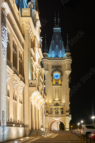 Clock tower of the Palace of Culture in Iasi, Romania. Evening illumination of the palace, cityscape. The building combines several architectural styles: neo-Gothic, romantic and neo-baroque. photo