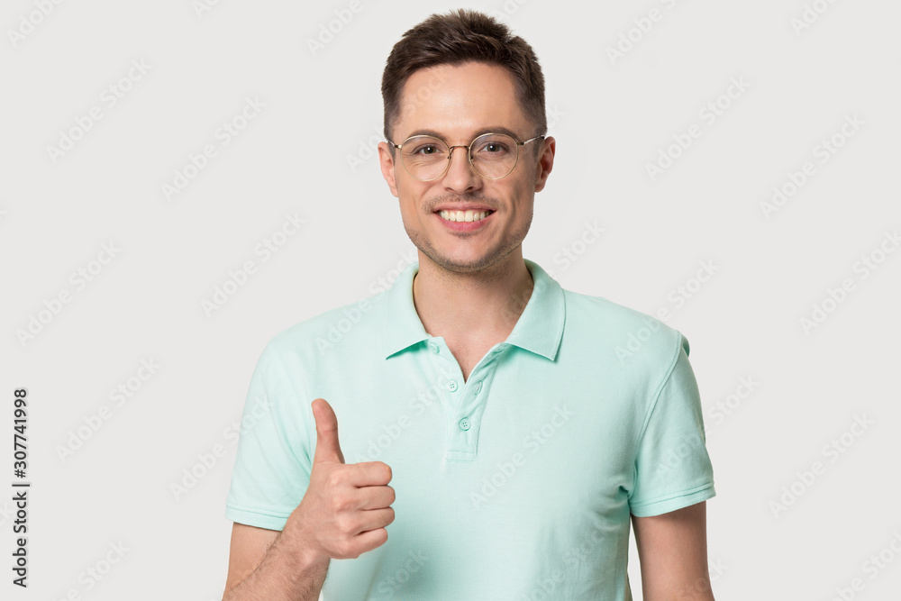 Happy smiling young man in glasses showing thumbs up. Happy smiling young man in glasses showing thumbs up.