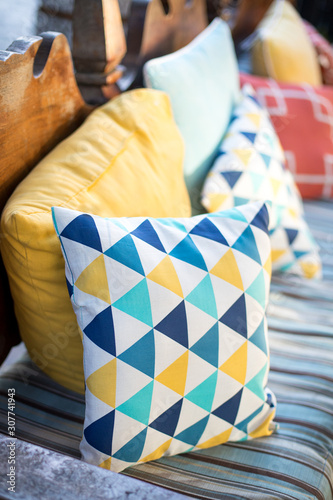 Colorful throw pillow on an cushioned bench