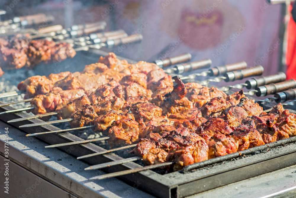 Pork on skewers cooked on barbecue grill. Preparation of shish kebab bbq