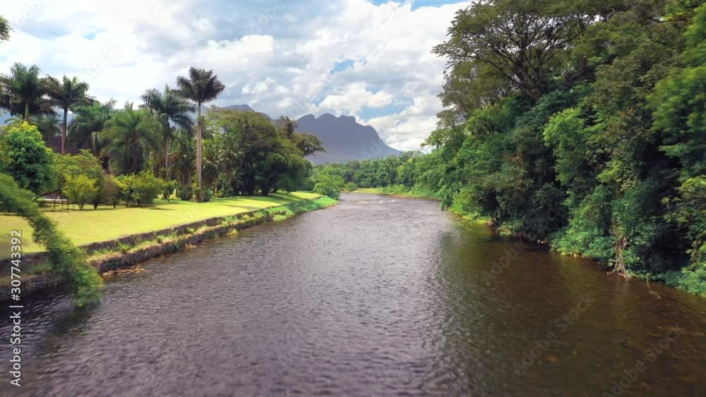 Brazilian river in tropical green forest going up revealing mountains in background Brazilian river in tropical green forest going up revealing mountains in background
