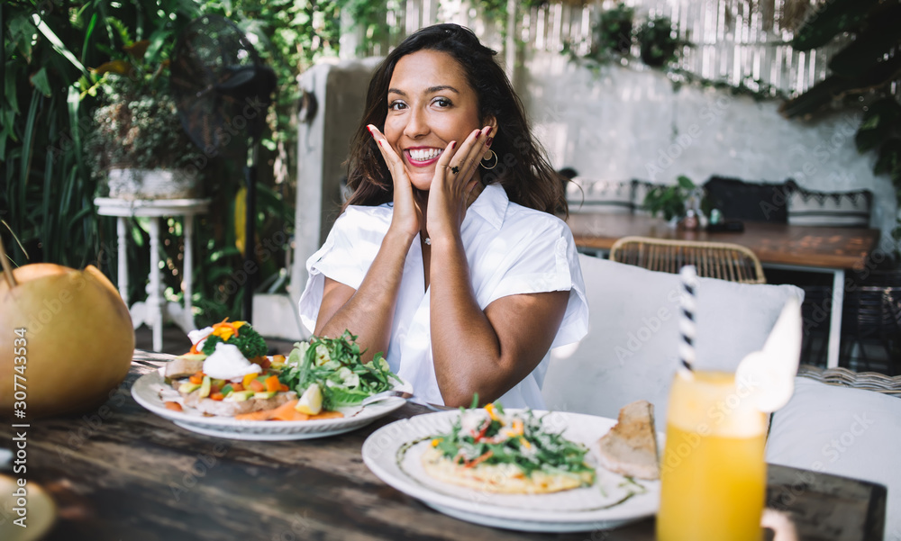 Flirty woman with served meal in cafe