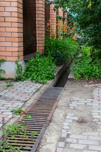 Stormwater drainage on city streets, street separation stormwater drainage, for drainage and separation of water from lawn and pavement. Drainage system for meltwater, rainwater flows and floods