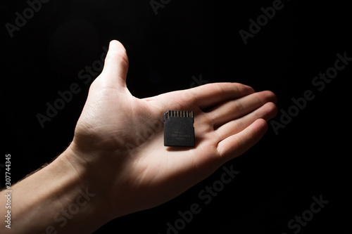 SD card in hand on a dark background