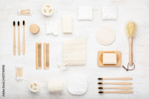 Zero waste with natural biodegradable accessories. Bamboo toothbrushes, handmade packaging free soap shampoo bars, cotton buds pads, hygiene products loofah on white, top view, selective focus