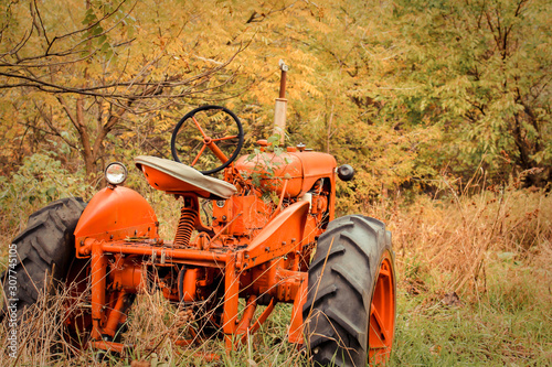 Bright Orange Tractor Against Yellow Autumn Forest