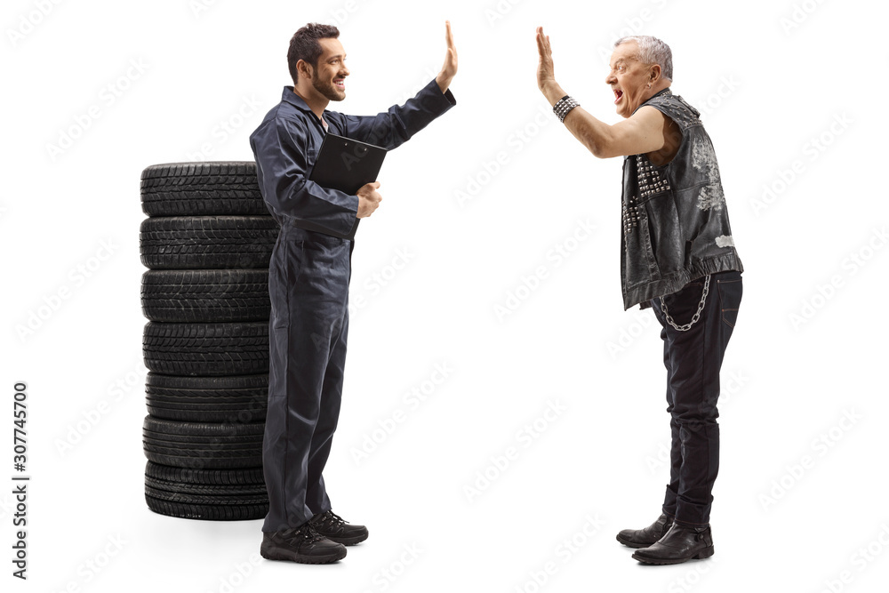 Auto mechanic and an elderly man in leather vest making high-five gesture Auto mechanic and an elderly man in leather vest making high-five gesture