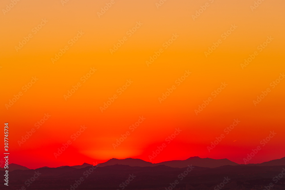 Breathtaking Sunset Silhouette: Orange and Red Sky over Hills