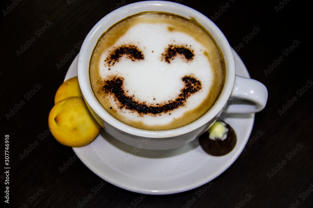 the cup of coffee with smile on the table. The biscuits with candy. Smile. Be happy with coffe the cup of coffee with smile on the table. The biscuits with candy. Smile. Be happy with coffe