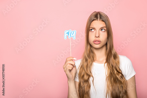 woman holding fly lettering on stick isolated on pink