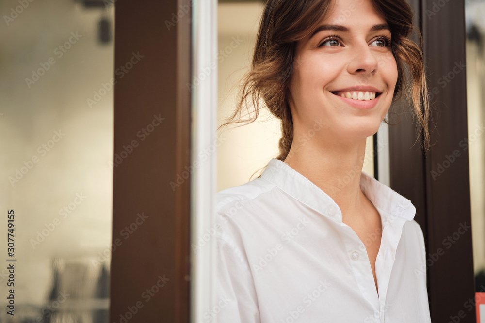 Portrait of young attractive woman happily looking away in workshop