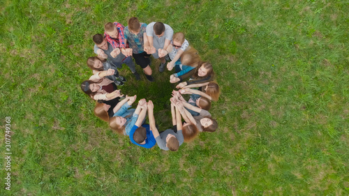 Friendly friends join hands together. Aerial view.