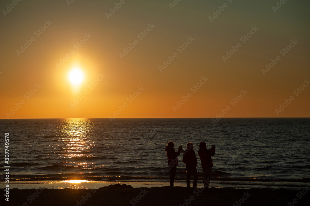 Rowy/Poland - June, 2019: People on the beach watching beaufiful sunset