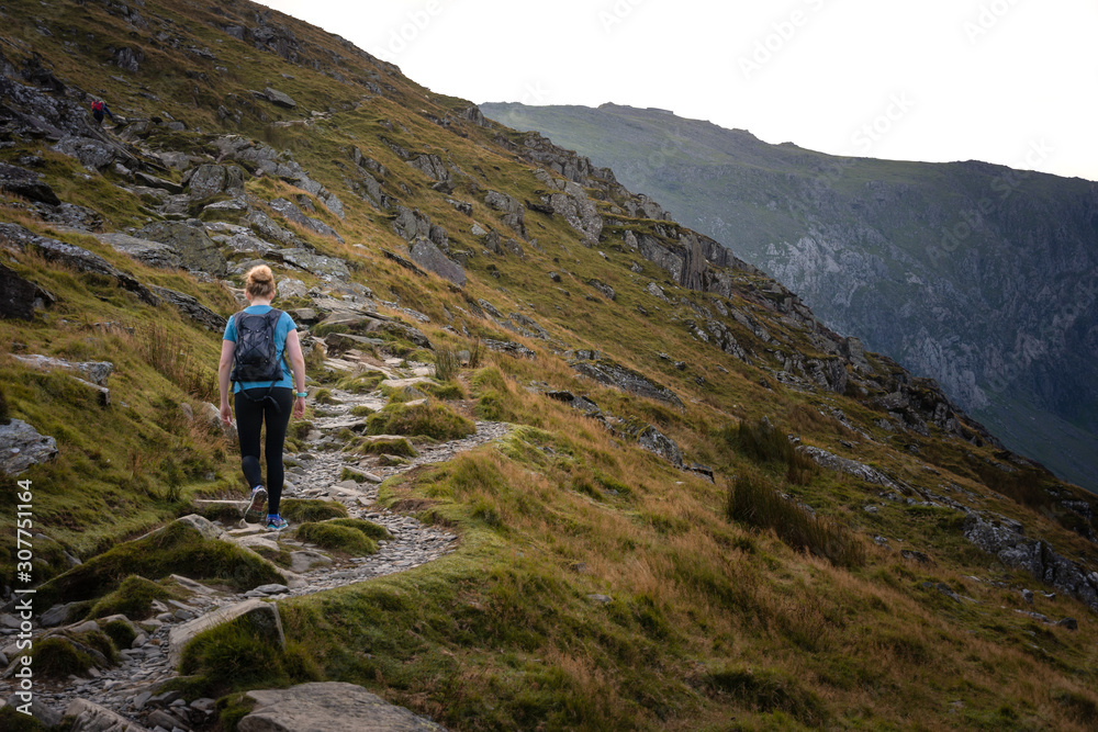 Young woman walking up mountain