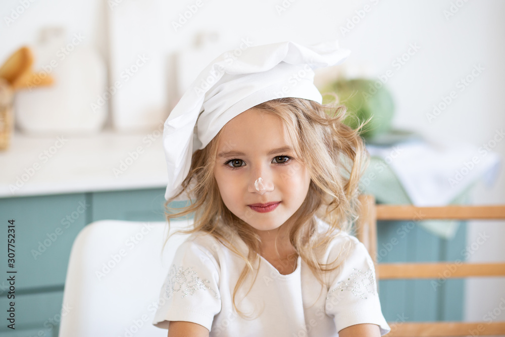 little cute girl with chef uniform in kitchen little cute girl with chef uniform in kitchen