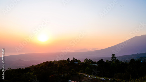 Lever de soleil rose et orange depuis le sommet d'une colline