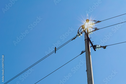 High voltage transmission line pylons against a blue summer sky.